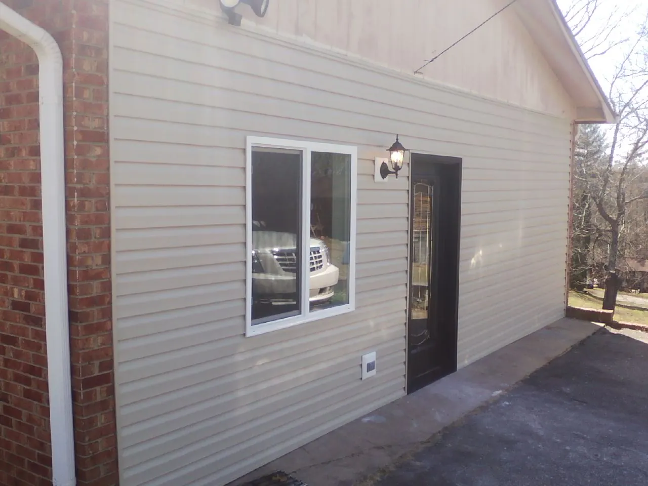 New vinyl siding and entry door on a room addition in Kinston