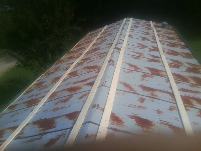 Rusted metal roof panels with new wood purlins before replacement — Storm Damage Roof Repair in Kinston by Roofing Brothers