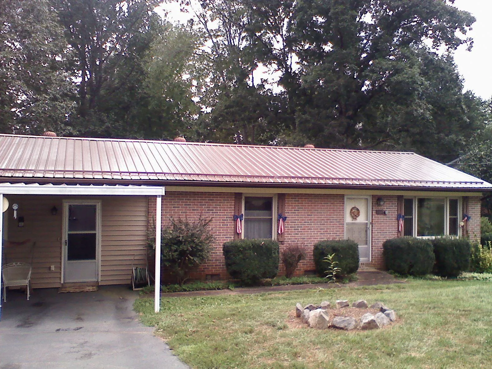 Bronze metal roof and carport on a brick ranch home — Roof Repair work by our crew in Kinston